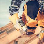 New Wooden House Roof Skeleton Assembling by Construction Contractor Worker. Construction Industry Theme.